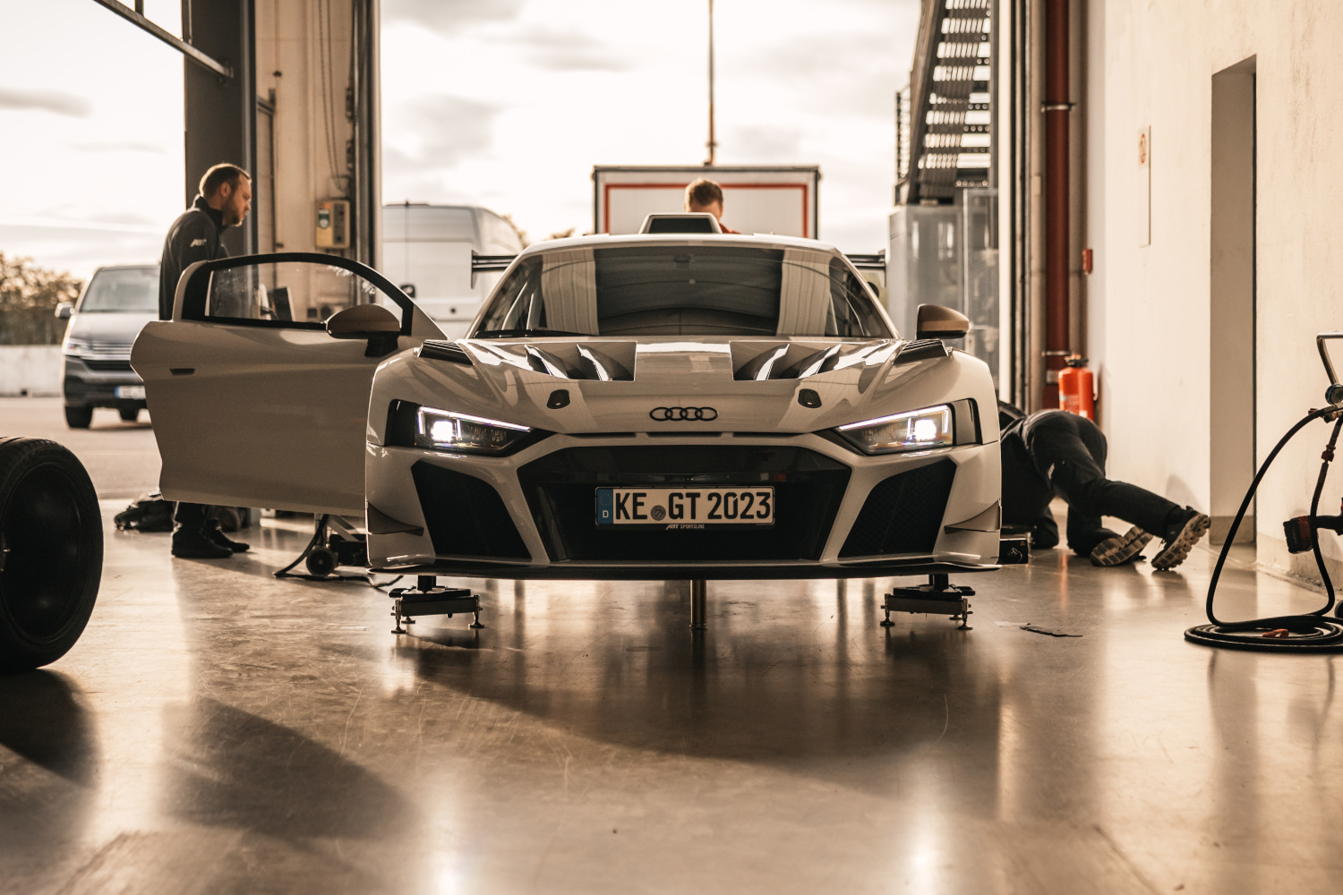 schwarz-weißer XGT aus der Frontansicht auf Hebebühne beim Reifenwechsel in Box 