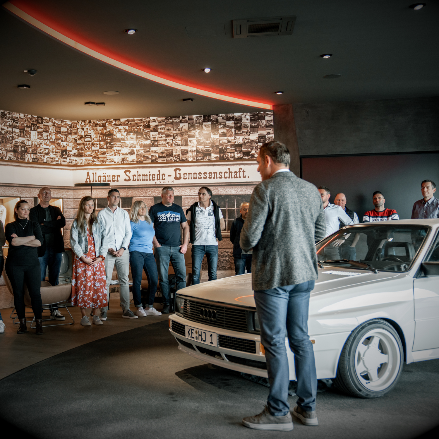 Hans-Jürgen Abt steht neben dem Ur-Quattro in der Edelschmiede und hält einen Vortrag