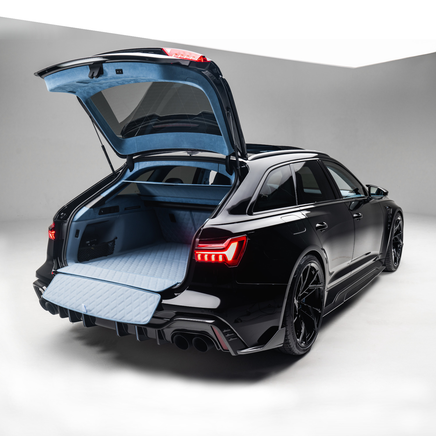 schwarzer RS6-LE aus der seitlichen Heckansicht mit offenem Kofferraum