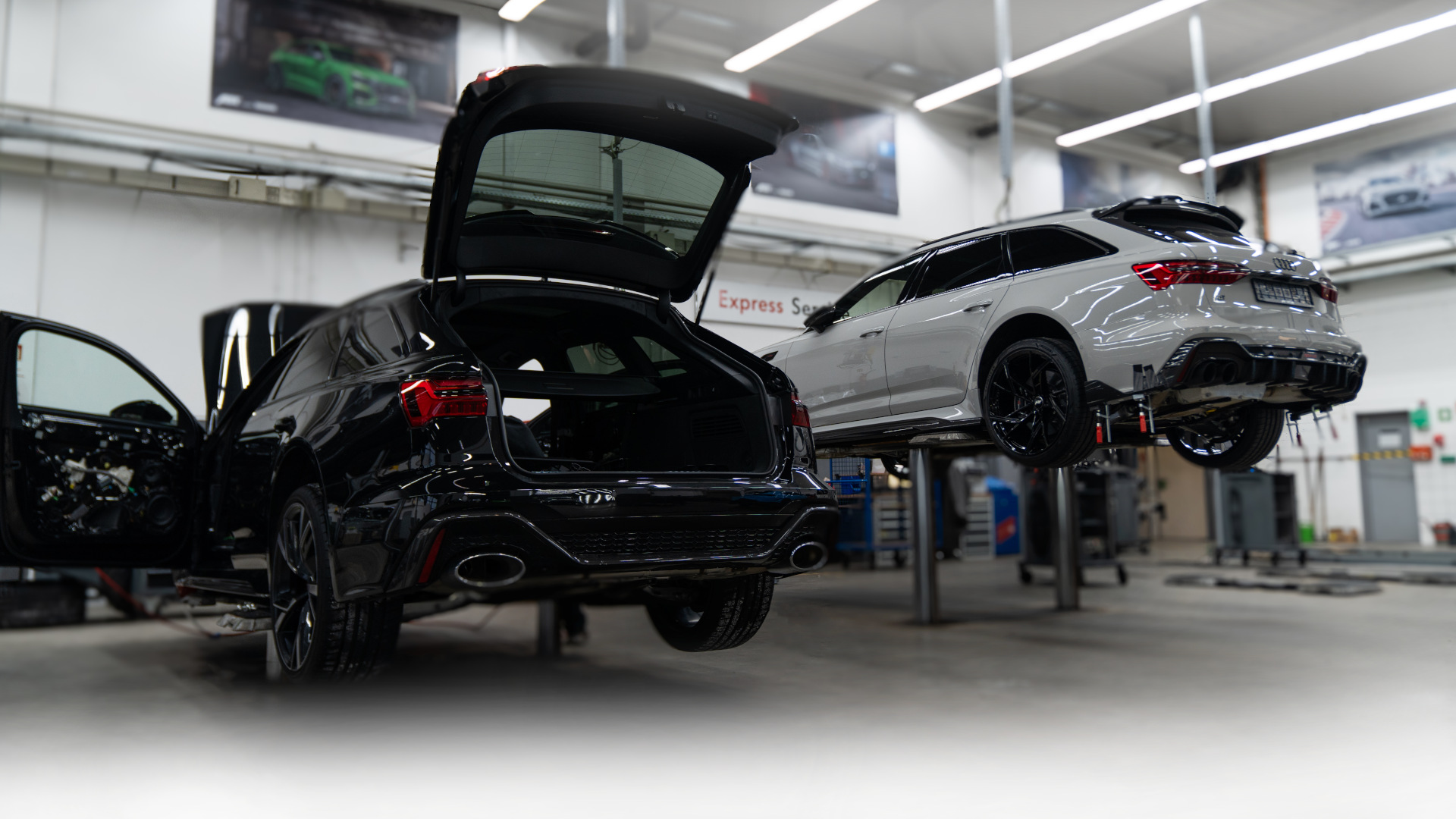 zwei Fahrzeuge auf der Hebebühne in der Werkstatt